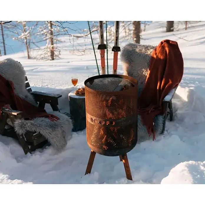 Bonfeu Chimenea de exterior Bonves - Ø x Al: 45 x 100 cm, Acero Corten, Marrón óxido - Fogón Bonfej de metal oxidado emitiendo calor, rodeado de nieve y asientos de invierno.