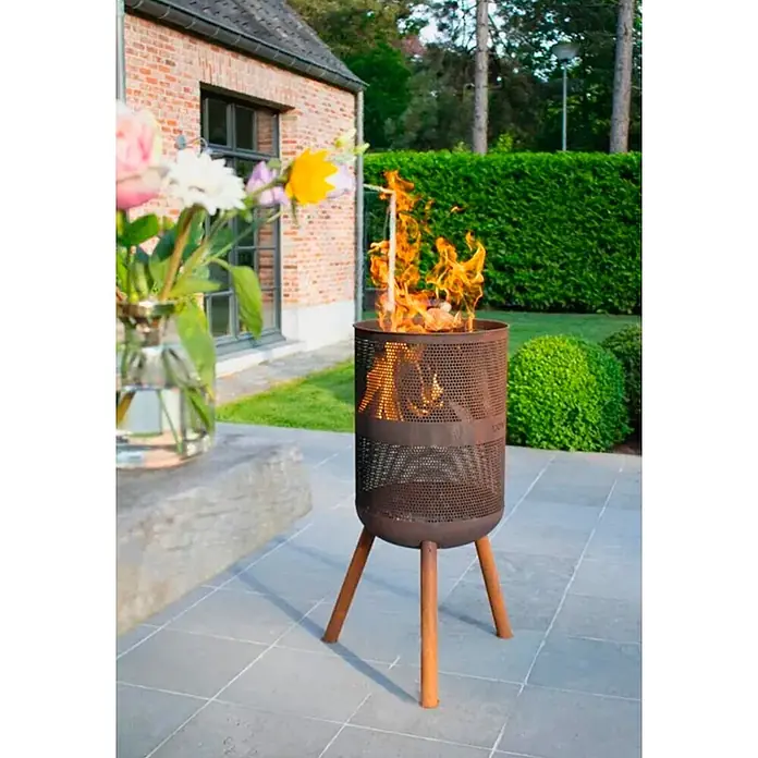Bonfeu Chimenea de exterior Bonves - Ø x Al: 45 x 100 cm, Acero Corten, Marrón óxido - Brasero perforado marrón oxidado con tres patas, ardiendo vivamente al aire libre en un patio.