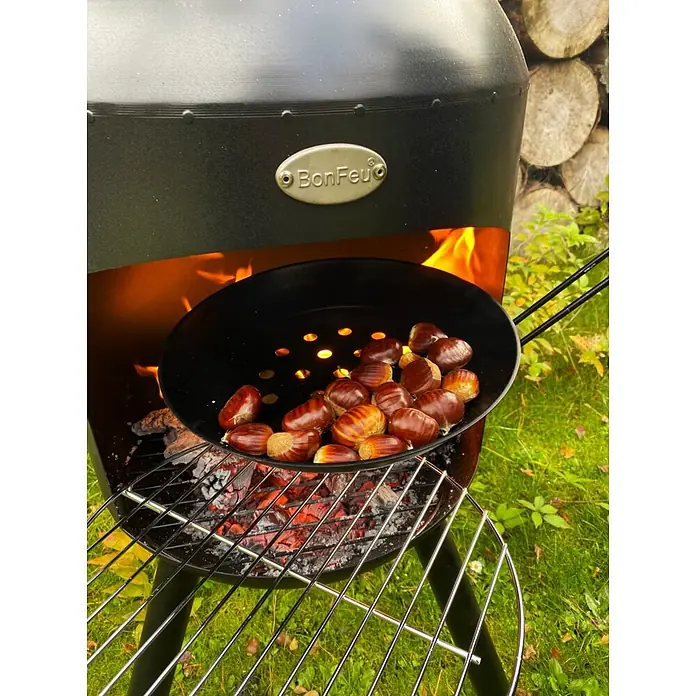 Bonfeu Chimenea de exterior Bonselo - Ø x Al: 39 x 147 cm, Acero, Negro - Chimenea exterior BonFeu negra asando castañas en una sartén sobre brasas encendidas en el jardín.
