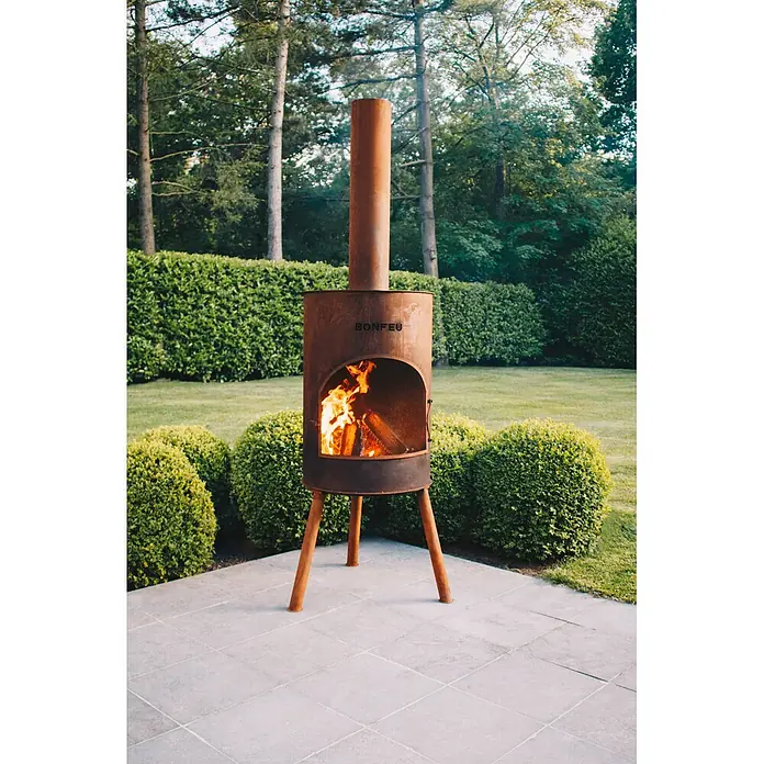 Bonfeu Chimenea de exterior Bonton - Ø x Al: 40 x 145 cm, Acero Corten, Marrón óxido - Chimenea exterior BONFEU de metal oxidado con fuego encendido, sobre un patio.