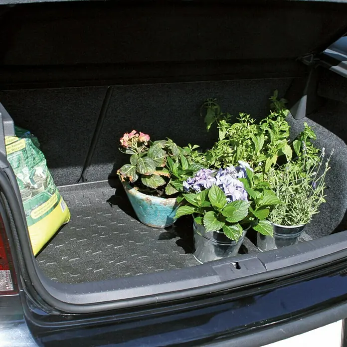 Cartrend Kofferraummatte - 90 x 50 cm - Der Kofferraum eines Autos ist mit Topfpflanzen und einem Sack Erde gefüllt, ideal für Hobbygärtner und Pflanzenliebhaber.