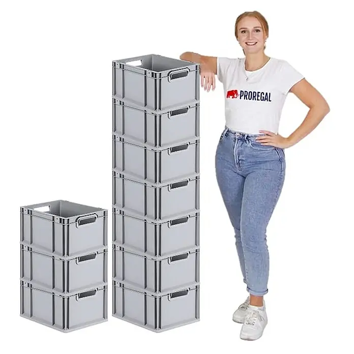 Eurobox NextGen Grip | HxBxT 22x30x40cm | 20 Liter | Griffe offen | Glatter Boden | Grau | Eurobehälter, Transportbox, Transportbehälter, Stapelbehälter, Box -  - Graue Kunststoff-Stapelboxen in hohen und kleineren Stapeln, daneben eine Frau zum Größenvergleich.