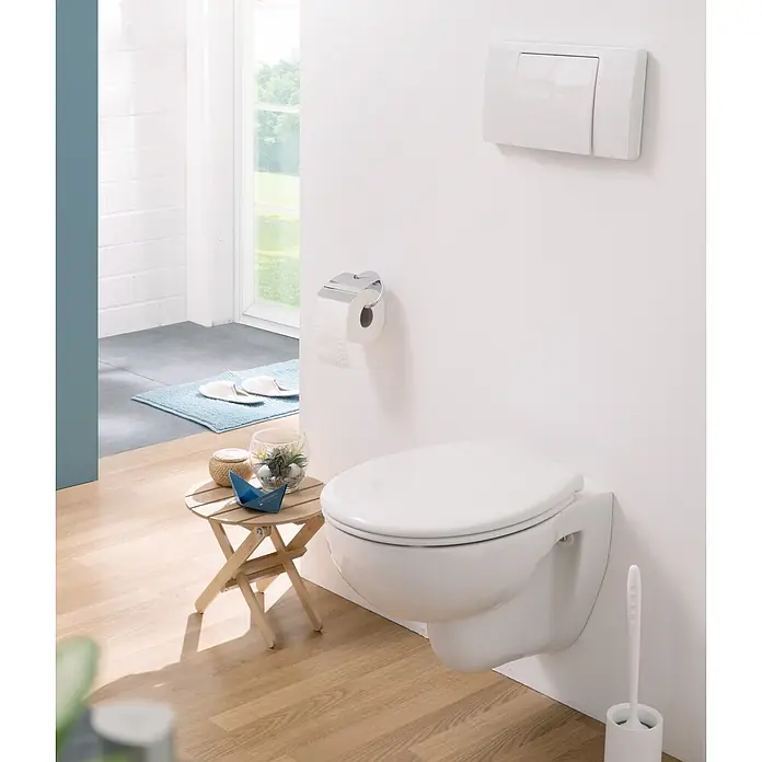 Calmwaters WC-Sitz Original - Duroplast, Weiß, Mit Absenkautomatik - Weißes Wand-WC in einem modernen Badezimmer mit hellem Holzboden. Darüber eine weiße Spülplatte.