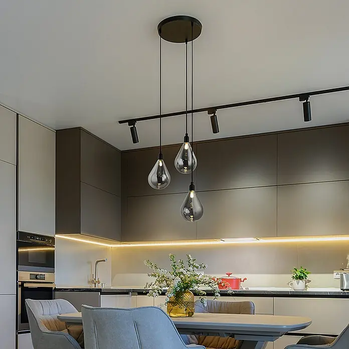 HOME DELUXE Hängeleuchte aus Glas CELIA Rauchgrau- 3-flammig -  - Drei schwarze Pendelleuchten mit rauchfarbenen Glas-Tropfenschirmen über einem Esstisch in einer modernen Küche.
