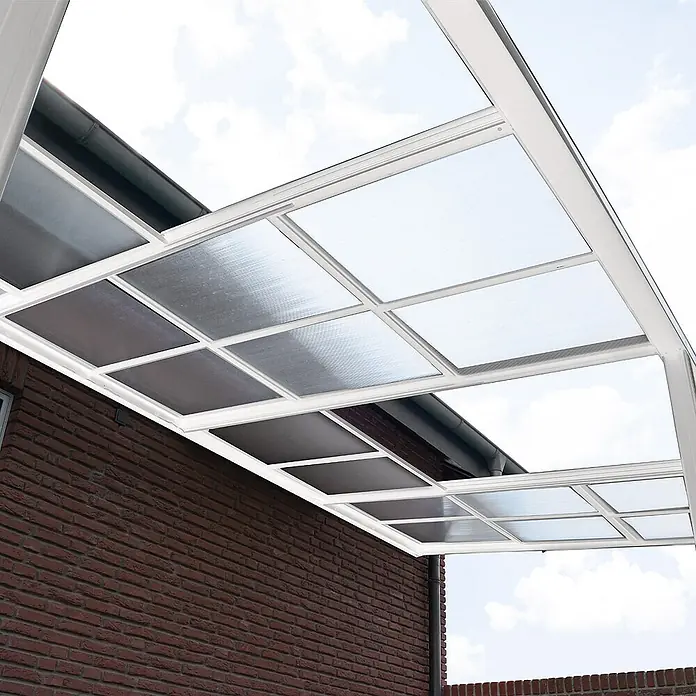 Home Deluxe Terrassenüberdachung SOLIS DELUXE Weiß 390 x 295 x 233 / 272 cm -  - Terrassenüberdachung mit weißem Rahmen und klaren sowie getönten Polycarbonatplatten an einer Ziegelwand.