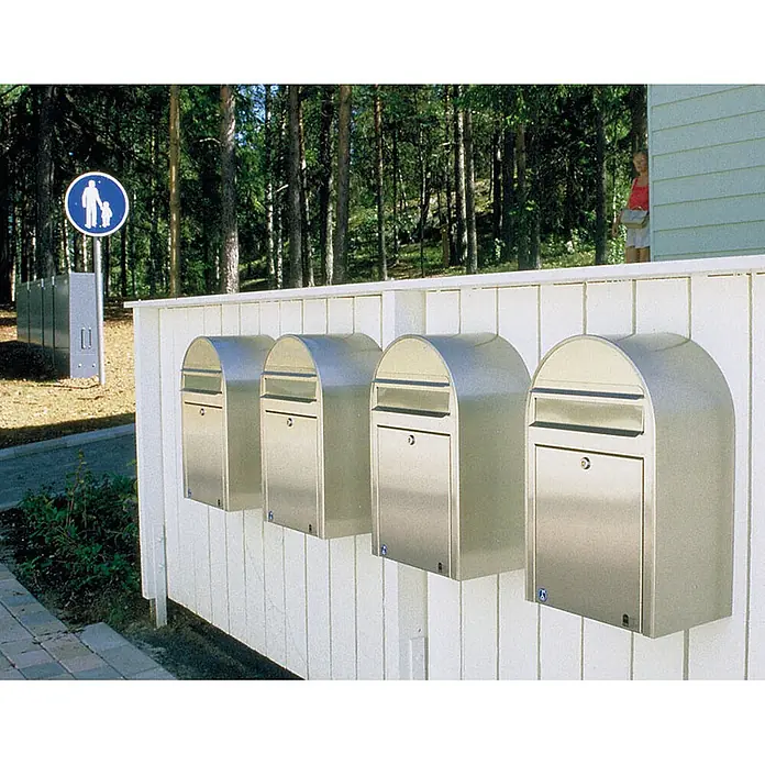 Proregal Wandbriefkasten Miami - Silber, Metall - Vier abgerundete Briefkästen aus Edelstahl an einem weißen Holzzaun im Freien.