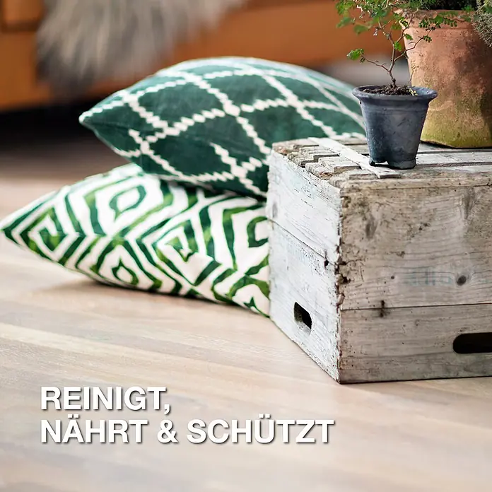 Bona Spray Mop Premium für geölte Holzfußböden - 1 x Spray Mop, 1 x nachfüllbare Kartusche mit 850 ml Reinigungsmittel, 1 x Microfaser-Reinigungspad - Heller Holzfußboden mit Kissen und Pflanzen, der eine gereinigte, genährte und geschützte Oberfläche zeigt.