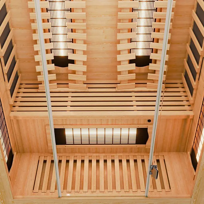 Infrarotkabine Kiruna130 Premium -  - Innenansicht einer hellen Infrarotsauna aus Holz mit mehreren leuchtenden Heizelementen an Wänden und Decke.