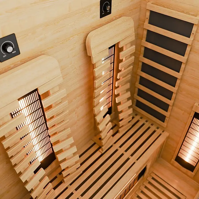 Infrarotkabine Kiruna130 Premium -  - Innenansicht einer hellen Infrarotsauna aus Holz mit Bänken, glühenden Heizungen und Bedienknopf.