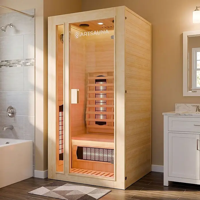 Infrarotkabine/Wärmekabine Nyborg S90V mit Vollspektrum-, Flächenstrahler & Hemlockholz -  - Hellholz-Infrarotsauna mit Glastür und "ARTSAUNA"-Logo, in modernem Badezimmer neben Dusche und Waschtisch.