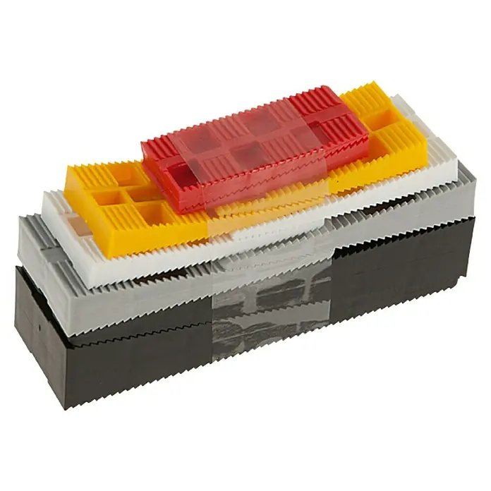 Montagekeile-Set - 10 Stk. - Ein Stapel verschiedenfarbiger Keile aus Kunststoff. Die Keile sind in Schwarz, Grau, Weiß, Gelb und Rot gehalten und weisen eine gezackte Oberfläche auf.