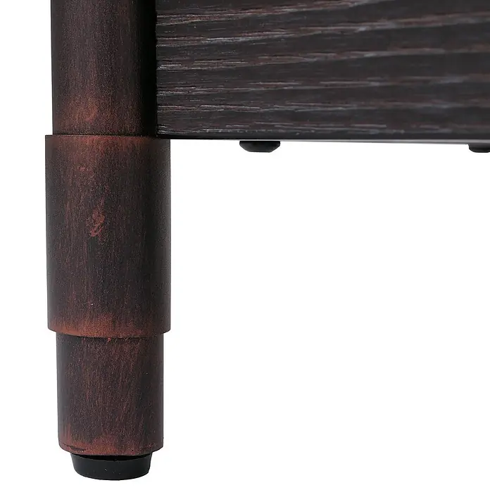 Mendler Kommode HWC-Q66 - L x B x H: 120 x 40 x 60 cm, Schwarz, Anzahl Schubladen: 4 Stk. - Nahaufnahme eines dunkelbraunen zylindrischen Möbelbeins mit gealterter Bronzeoptik und schwarzem Fußpolster, neben einer dunkelbraunen Holzmaserung-Möbelseite.
