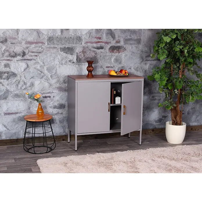 Mendler Kommode HWC-L84 - L x B x H: 90 x 40 x 90 cm, Grau - Ein grauer Metallschrank mit Holzplatte, eine Tür leicht geöffnet mit Büchern darin, vor einer Steinwand in einem Raum.