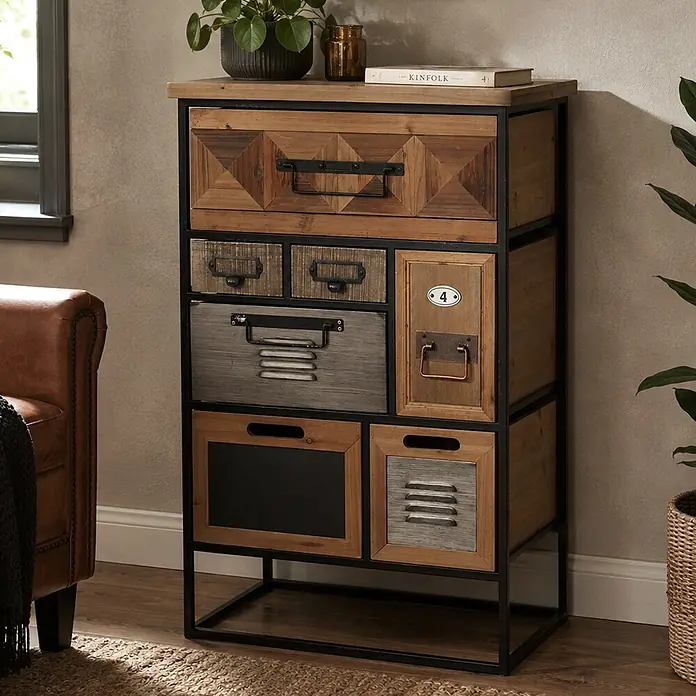 Mendler Kommode HWC-Q78 - L x B x H: 53 x 31 x 84 cm, Mehrfarbig, Anzahl Schubladen: 7 Stk. - Industrieller Mehrschubladenschrank mit verschiedenen Holzoberflächen, schwarzem Metallrahmen und Griffen, im Wohnzimmer neben einem Sessel.