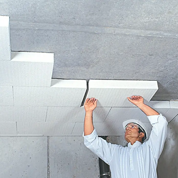 Mineraldämmplatte Multipor - 60 x 10 x 39 cm, 4 Stk. - Ein Bauarbeiter montiert weiße Dämmplatten an einer Betondecke, um die Isolierung des Raumes zu verbessern.