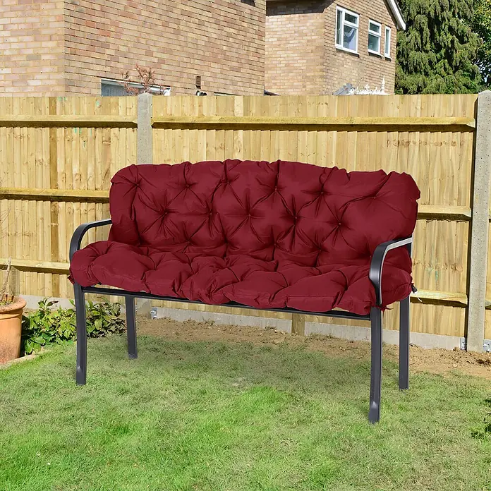 SONNENH Bankauflage - 1 Stk., L x B x H: 150 x 98 x 8 cm, Polyester, Rot - Rotes gestepptes Kissen auf einer schwarzen Metallgartenbank, auf Gras im Garten.