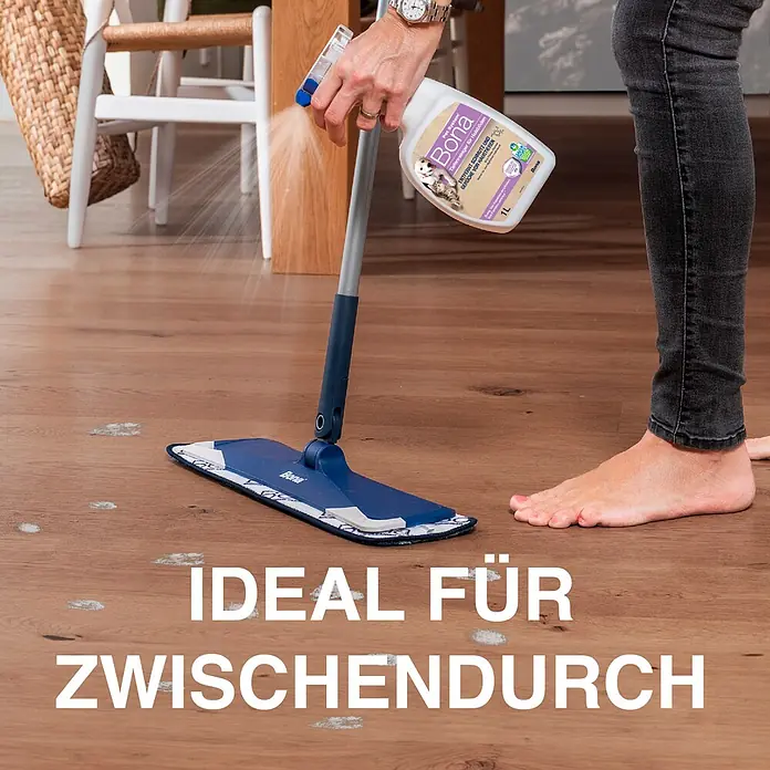 Bona Pet System Reinigungsmittel Tiefenreiniger für Holzböden - 1 l, Flasche mit Sprühkopf - Eine Person reinigt einen Holzboden mit Bona Pet System Spray und Wischmopp.