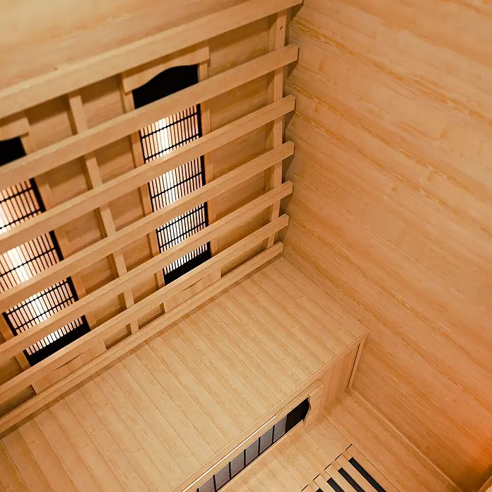 Infrarotkabine Oslo mit Vollspektrumstrahler -  - Innenansicht einer hellen Holzsauna mit Latten-Infrarotstrahlern und Holzbank.