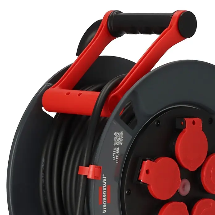 Brennenstuhl Kabeltrommel 300 KU 2100 - Kunststoff, 25 m, H07RN-F, IP44 - Graue Kabeltrommel mit schwarzem Kabel, rotem Griff und mehreren rot abgedeckten Steckdosen.