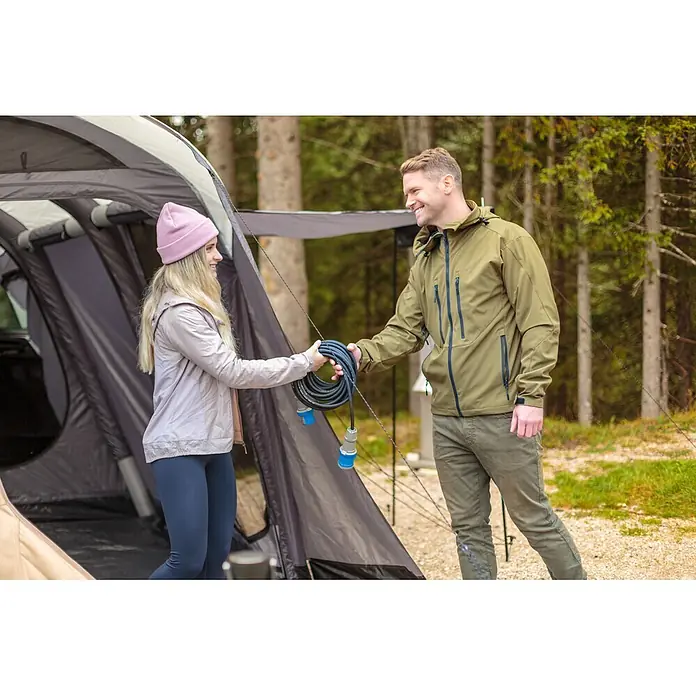 Brennenstuhl Verlängerungskabel Camping-CEE - 10 m, IP44, H07RN-F - Zwei Personen tauschen ein schwarzes Stromverlängerungskabel mit blauen Steckern auf einem Campingplatz aus.