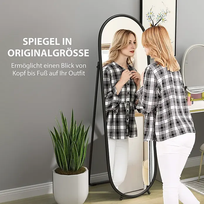 Homcom Standspiegel - Transparent, Glas - Eine Frau steht vor einem schwarz gerahmten Standspiegel und überprüft ihr Outfit.