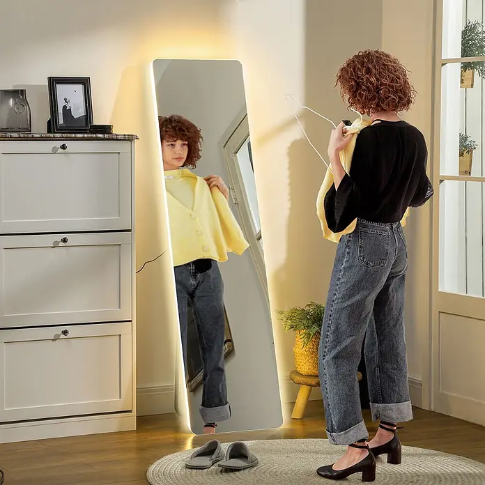 Homcom Standspiegel - Gold, Glas - Ein Ganzkörper-LED-Spiegel, der eine Person beim Anprobieren einer gelben Strickjacke in einer häuslichen Umgebung zeigt.
