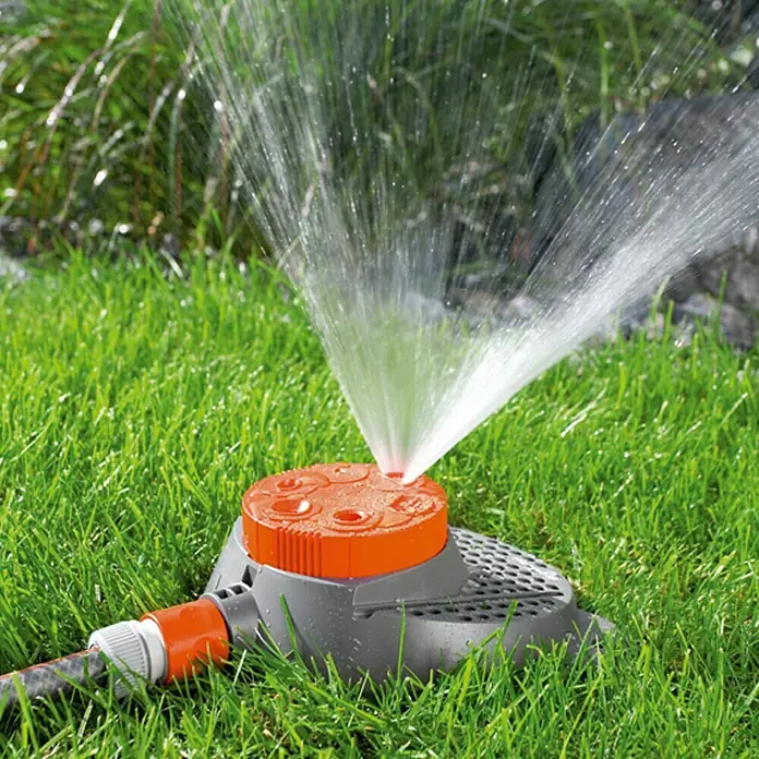 Gardena Classic Regner Boogie - Kunststoff, Anzahl Sprühformen: 6 Stk. - Rasensprenger in Aktion. Der orangefarbene Sprenger bewässert mit seinem Sprühnebel den grünen Rasen im Garten.