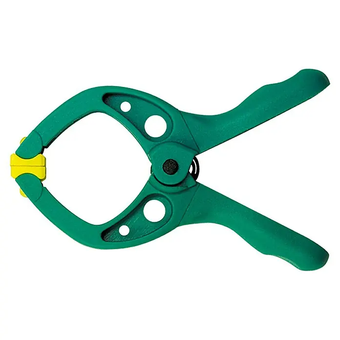 Wolfcraft Federzwinge Microfix - Spannweite: 20 mm, Ausladung: 20 mm - Nahaufnahme einer grünen Federklemme mit gelben Spitzen, ein Werkzeug für verschiedene Bastel- und Tischlerarbeiten.