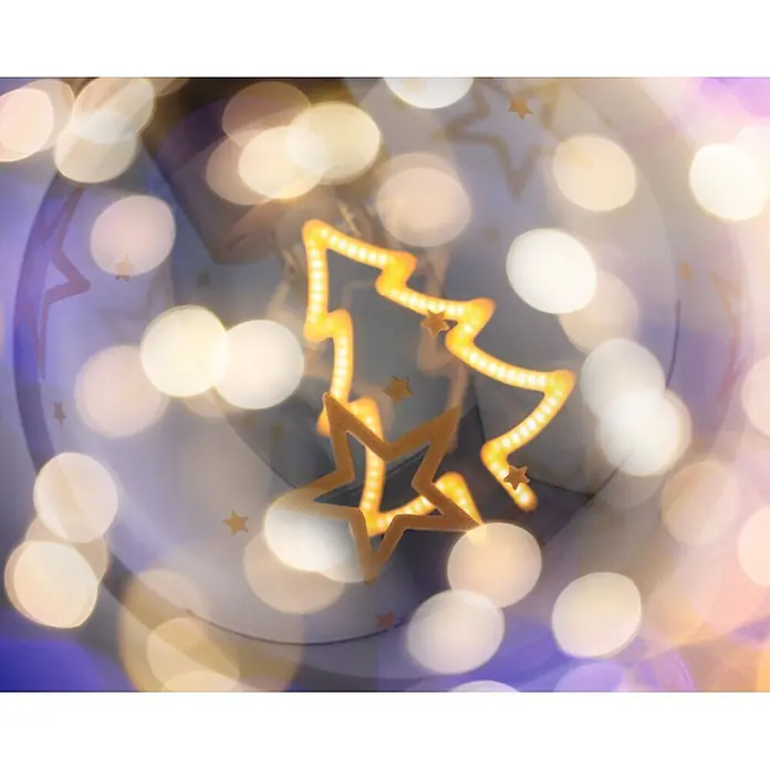 Paulmann LED-Weihnachtsdekoleuchte Christmas Globe - Braunglas, Batteriebetrieben, LED - Leuchtende gelbe Weihnachtsbaum-Dekoration und goldene Sterne, umgeben von verschwommenen Festlichtern.