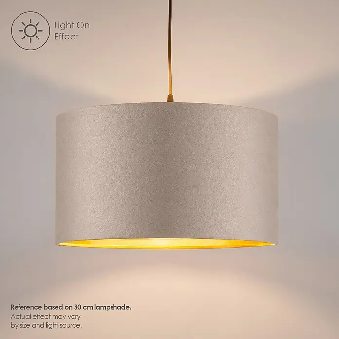 Home Sweet Home Lampenschirm Velvet - Grau-Gold, E27, 30 x 30 x 20 cm - Ein hellgrauer zylindrischer Lampenschirm mit goldener Innenseite leuchtet und wirft ein warmes Licht.