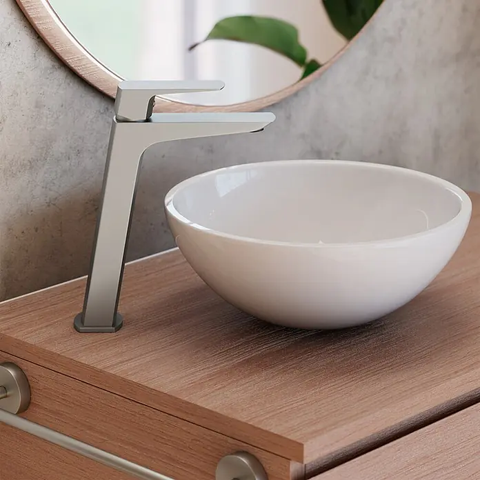 IO Grifo de lavabo alto Marriot - Nickel - Grifo plateado moderno y lavabo tipo bol blanco sobre un mueble de baño de madera.