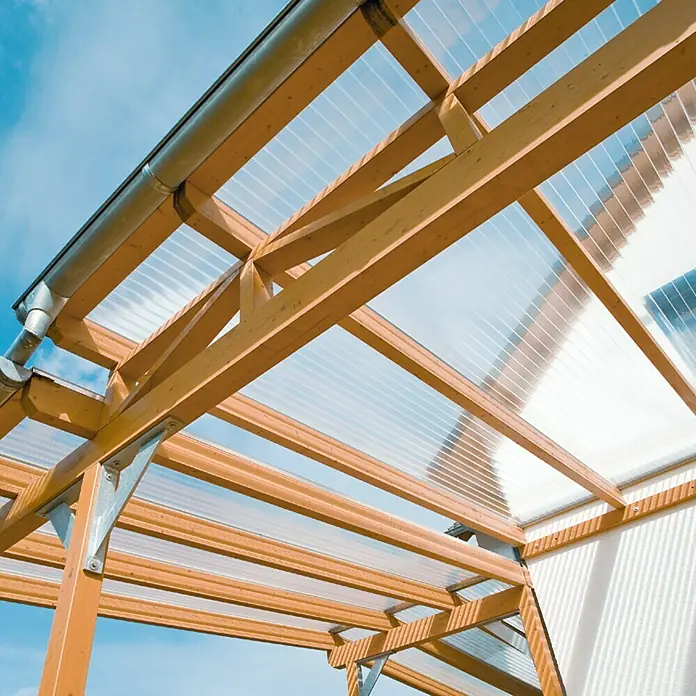 PLEXIGLAS® Acrylglas-Stegplatte proTerra - 2.000 x 980 x 16 mm, Acrylglas (PMMA), Transparent - Nahaufnahme einer Überdachung mit Holzrahmen und durchsichtigen Polycarbonatplatten, die natürliches Licht hereinlassen.