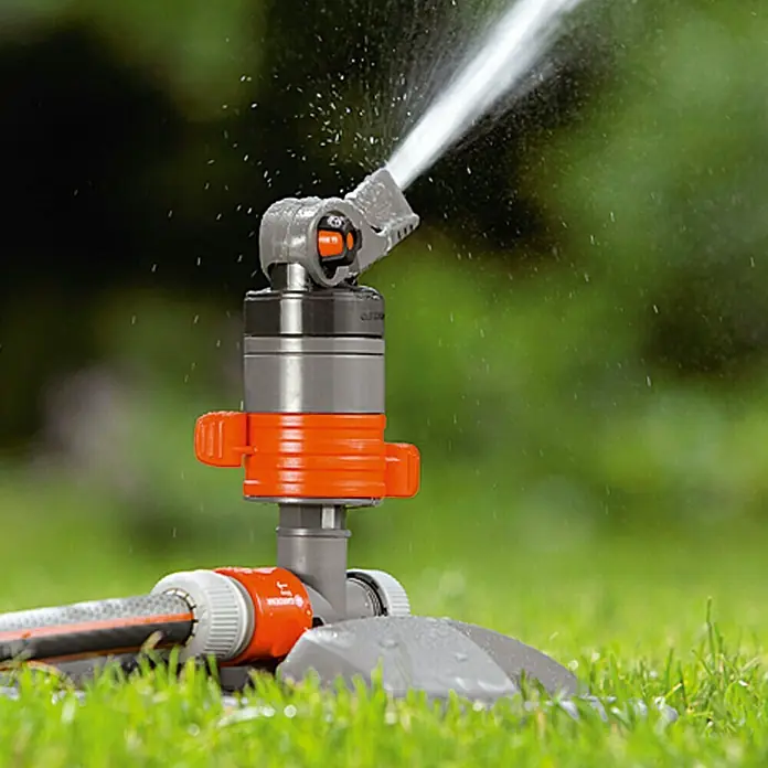 Gardena Comfort Turbinenregner - 20 ° - 360 °, Kunststoff, Mit Schlitten - Nahaufnahme eines Rasensprengers der Marke Gardena, der Wasser versprüht, ideal für die Gartenbewässerung.