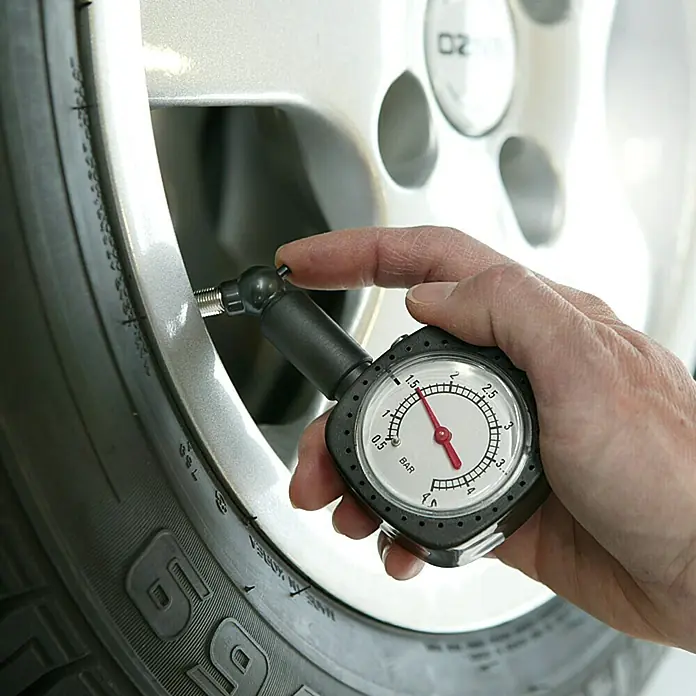 UniTEC Reifendruckprüfer - Autoventil, Analog - Eine Person benutzt ein Reifendruckmessgerät, um den Reifendruck eines Reifens zu überprüfen. Das Messgerät zeigt einen Wert von etwa 1,6 Bar an.