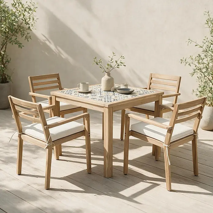 Set aus Gartentisch und -stühlen für 4 Personen aus Akazienholz und Keramik FARO -  - Ein Outdoor-Essset aus hellem Holz mit gefliester Tischplatte und vier Stühlen mit weißen Kissen auf einer Holzterrasse.