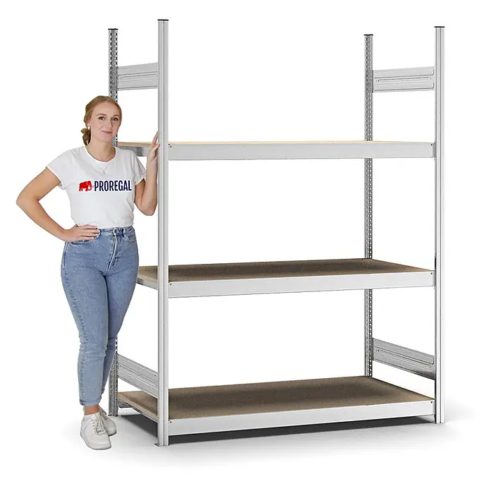 Proregal Schwerlastregal MAGNUS Stecksystem - H x B x T: 200 x 150 x 60 cm, Traglast pro Boden: 350 kg, Anzahl Böden: 3 Stk., Stecken, Verzinkt - Frau steht neben einem hohen, grauen Metallregal mit vier braunen Böden, das seine Größe zeigt.