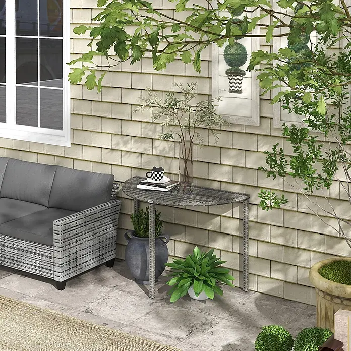 Outsunny Rattan Beistelltisch Grau L100 x B50 x H74 cm -  - Graues Outdoor-Sofa im Rattan-Stil mit dunklen Kissen und passendem Halbmond-Tisch auf einer Terrasse.