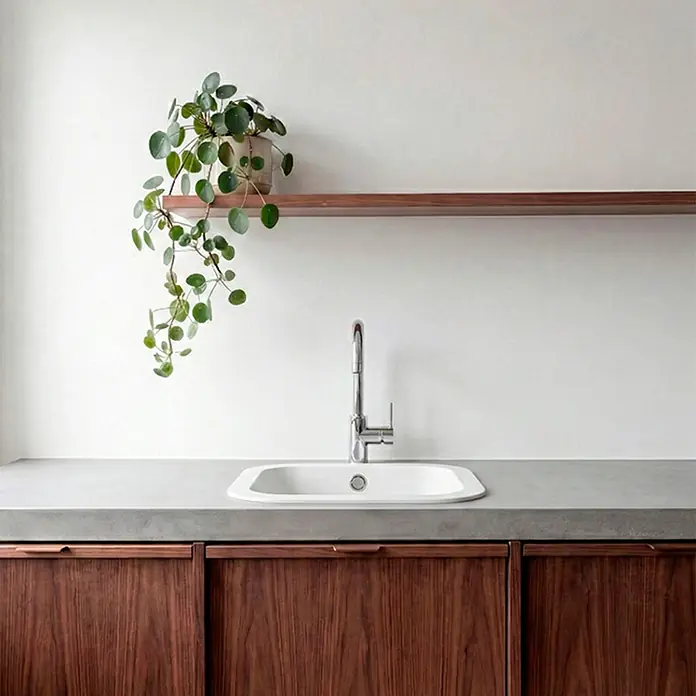 Poalgi Fregadero encastrable Ámbar - 48,5 x 48,5 cm, Material compuesto, Blanco - Encimera de cocina moderna con superficie gris tipo piedra, fregadero blanco, grifo cromado y muebles de madera oscura. Estante de madera con planta.