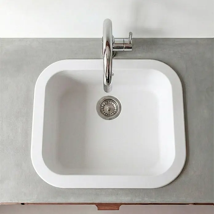 Poalgi Fregadero encastrable Ámbar - 48,5 x 48,5 cm, Material compuesto, Blanco - Fregadero de cocina blanco con grifo cromado, instalado en una encimera gris.