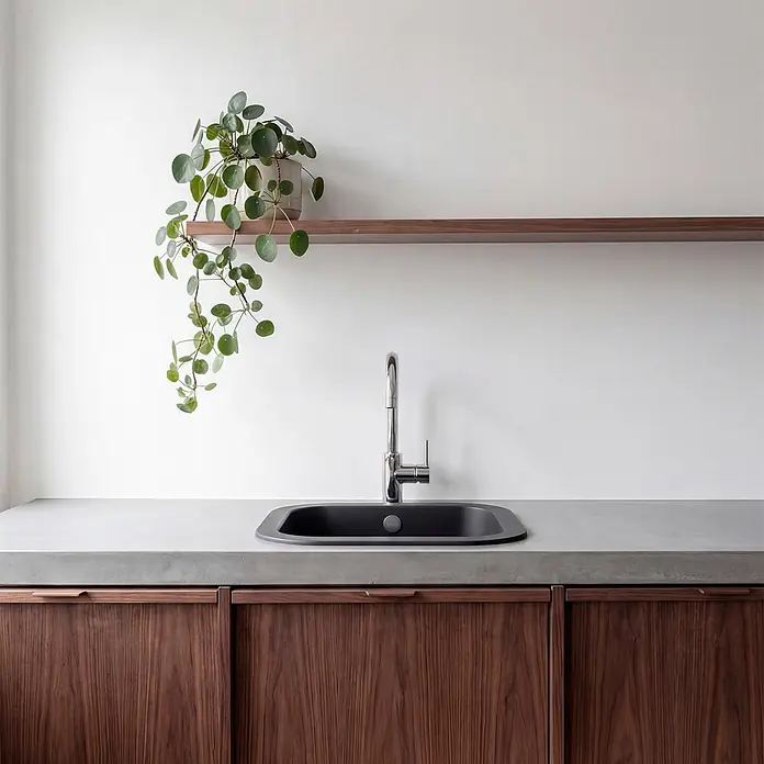 Poalgi Fregadero encastrable Ámbar - 48,5 x 48,5 cm, Material compuesto, Negro - Encimera de cocina con fregadero gris oscuro, encimera de hormigón gris claro y gabinetes de madera oscura con tiradores integrados.