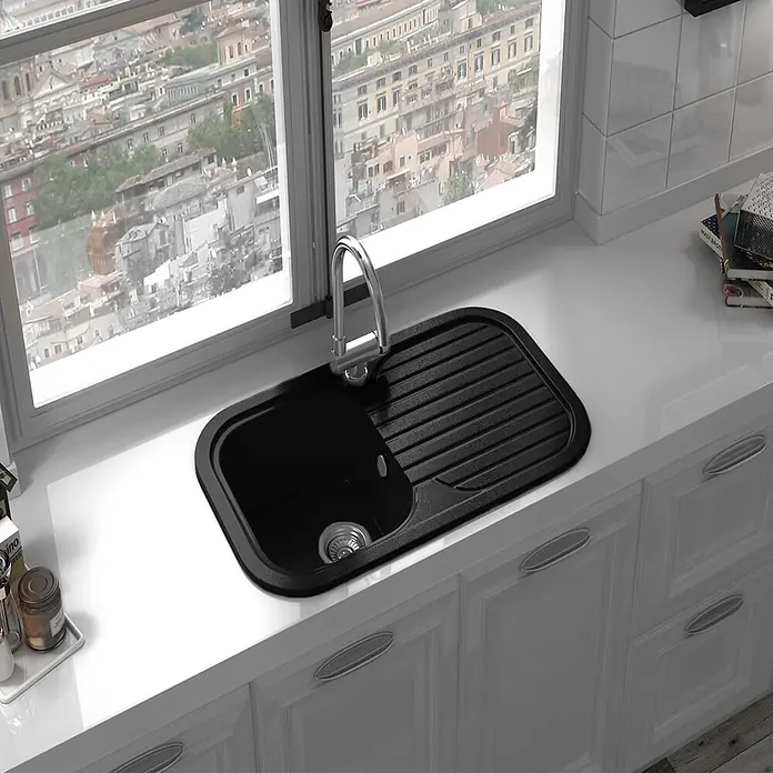 Poalgi Fregadero encastrable Coral - 48,5 x 81 cm, Negro - Fregadero de cocina negro con escurridor integrado, instalado en encimera blanca junto a una ventana.