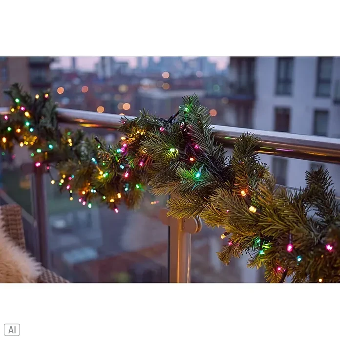 Konstsmide LED-Clusterlichterkette Pastell - Außen, Länge: 8,78 cm, 400 Stk., Netzbetrieben - Grüne Weihnachtsgirlande mit bunten Lichterketten um ein Balkongeländer gewickelt, die eine festliche Stadtansicht schmückt.