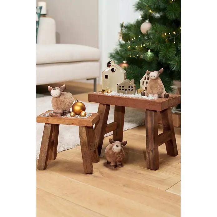 Dekoartikel LED Haus - 1 Stk., Sortiert, 8 x 4,5 x 7 cm - Zwei dunkelbraune Holzschemel, einer kleiner, mit Weihnachtsfiguren, Häusern und goldenen Kugeln festlich dekoriert.