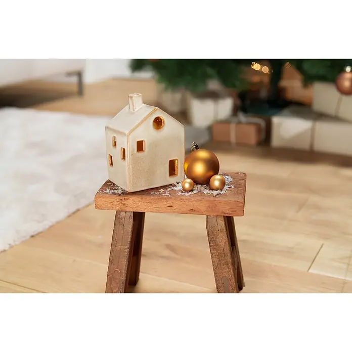 Dekoartikel LED Haus - 1 Stk., Sortiert, 10 x 8 x 14,5 cm - Keramikhaus-Dekoration auf Holzhocker mit goldenen Weihnachtsornamenten.