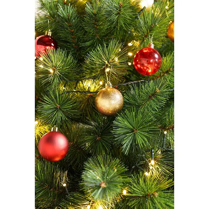 Christbaumkugel-Set - Gold, Kunststoff, 48 Stk., Durchmesser: 6 cm - Nahaufnahme eines grünen Weihnachtsbaums mit warmweißen Lichtern sowie roten und goldenen Kugeln.