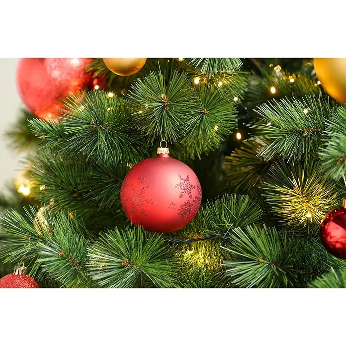 Christbaumkugel - Rot, Glas, Rund, 4 Stk. - Festlicher Weihnachtsbaum mit grünen Nadeln, warmen Lichtern und roten, goldenen Kugeln, darunter eine glitzernde rote Schneeflocken-Kugel, aus der Nähe.