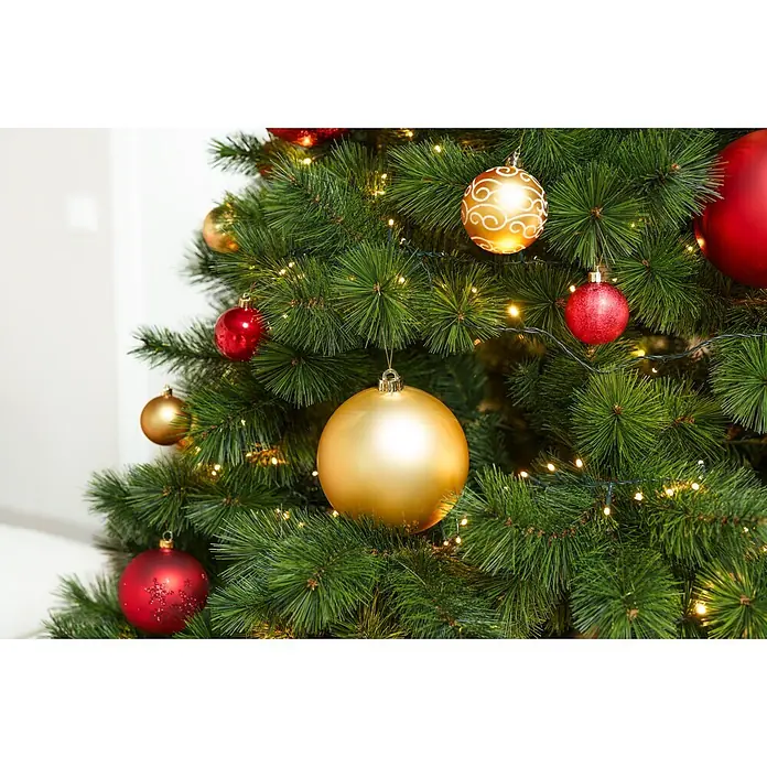 Christbaumkugel-Set - Gold, Kunststoff, 48 Stk., Durchmesser: 6 cm - Nahaufnahme eines grünen Weihnachtsbaums, geschmückt mit roten und goldenen Kugeln und warmen Lichterketten.
