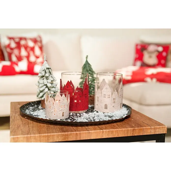 Teelichthalter Filzhaus - 1 Stk., Sortiert, 7 x 8 cm - Drei festliche Kerzenhalter mit hausförmigen Filzüberzügen, dekoriert mit Bäumen und Kunstschnee auf einem Tablett, schaffen winterliche Stimmung.