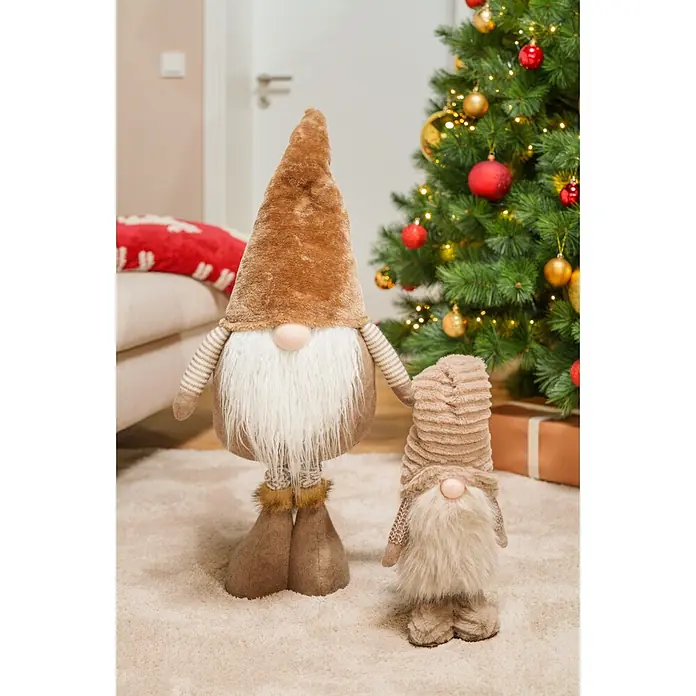 Dekofigur Weihnachtsmann - L x B x H: 18 x 13 x 65 cm, Textil - Zwei Plüsch-Weihnachtswichtel mit braunen Mützen und weißen Bärten, einer größer, als festliche Dekoration neben einem geschmückten Weihnachtsbaum.