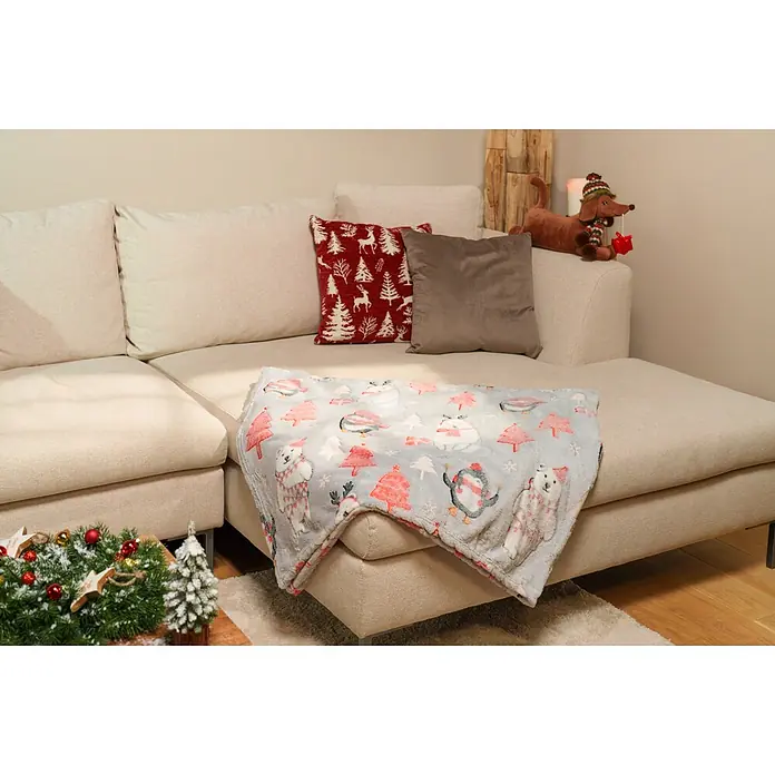 Kissen Gloria - 45 x 45 cm, Rot, Quadratisch - Eine gemütliche grau-rote Weihnachtsfleecedecke mit Eisbären, Pinguinen und Bäumen, drapiert auf einem hellbeigen Sofa im weihnachtlichen Wohnzimmer.